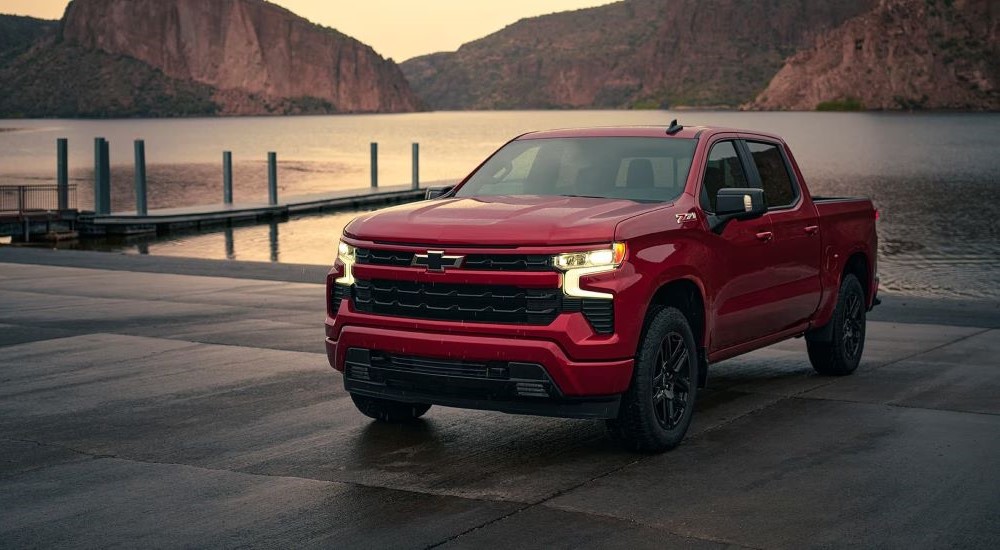 A red 2023 Chevy Silverado 1500 Z71 is shown from the front parked by a lake.