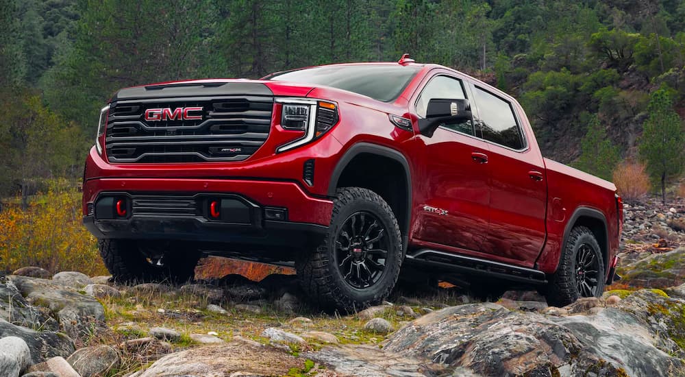 A red 2023 GMC Sierra 1500 AT4X is shown off-roading after leaving a GMC Sierra dealer.
