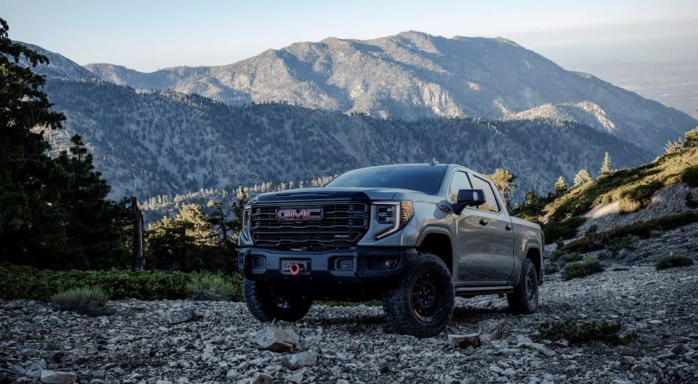 A grey 2024 GMC Sierra 1500 AT4 AEV is shown from the front at an angle after leaving a Ripley GMC dealer.