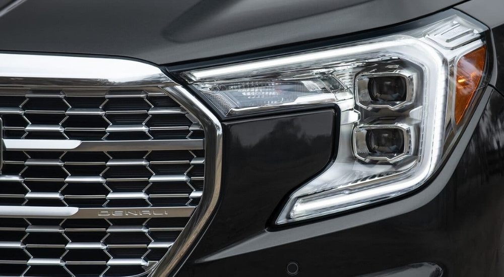 A close up shows the driver side headlight on a black 2024 GMC Terrain Denali.