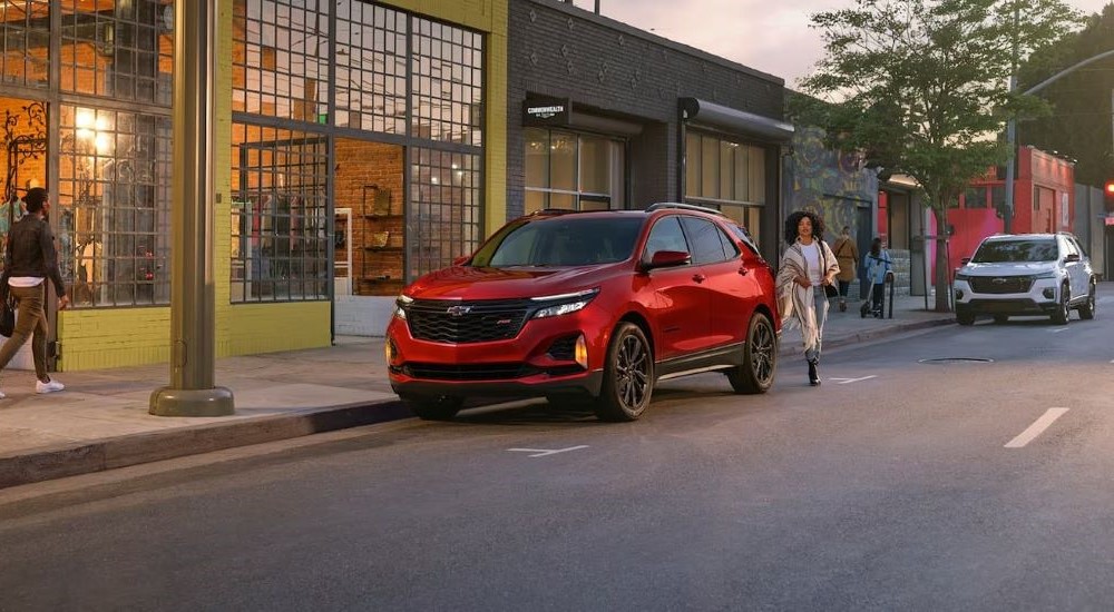 A red 2024 Chevy Equinox RS parked on a city street after visiting a Chevy dealer near Henderson.