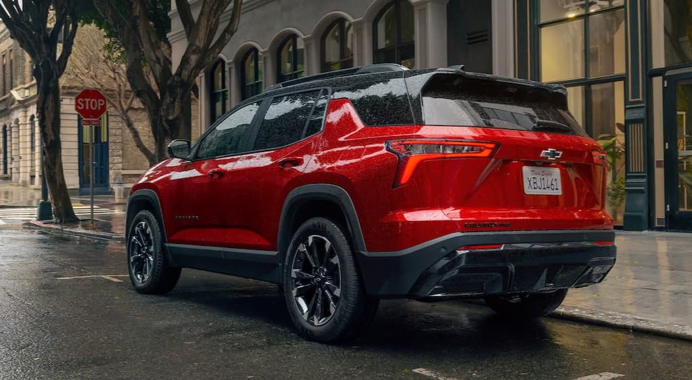 A red 2025 Chevy Equinox RS parked near a stop sign.