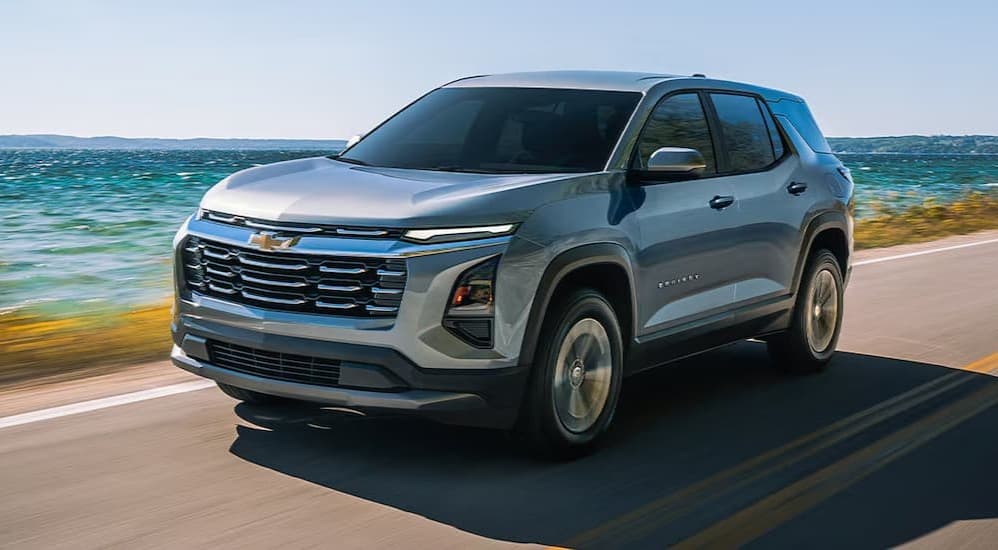 A silver 20226 Chevy7 Equinox for sale driving near water.