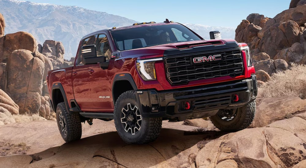 A red 2025 GMC Sierra 2500 AT4X parked off-road.