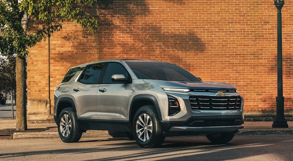 Grey 2026 Chevy Equinox for sale in Corinth parked beside a brick wall.