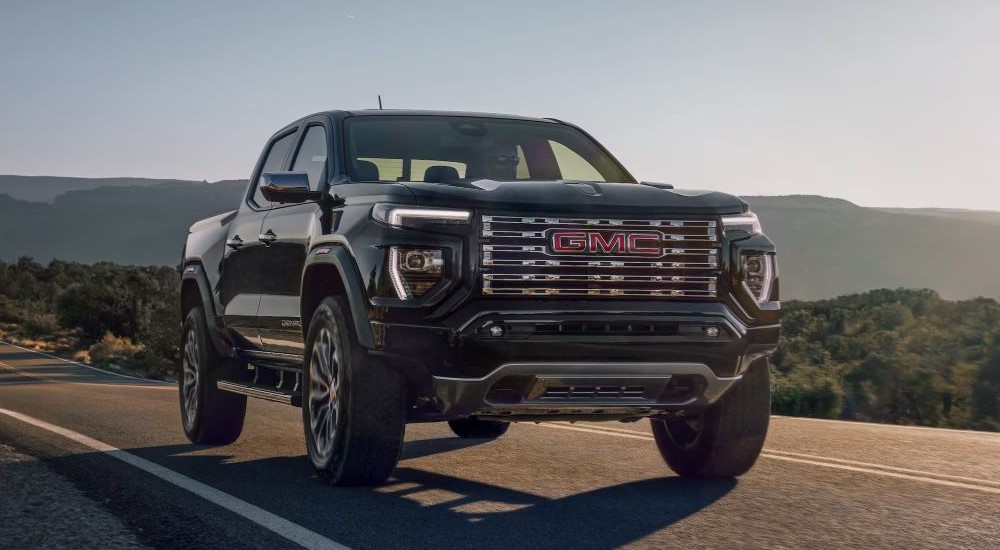 Black 2025 GMC Canyon Denali driving from a dealer with GMC trucks for sale near Ripley.