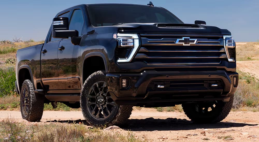 Black 2026 Chevy Silverado 2500HD parked on sandy dunes