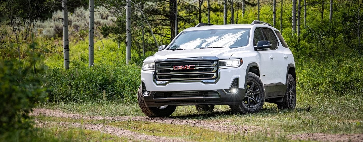 A white 2020 GMC Acadia AT4 is shown from the front at an angle after leaving a New Albany GMC dealer.
