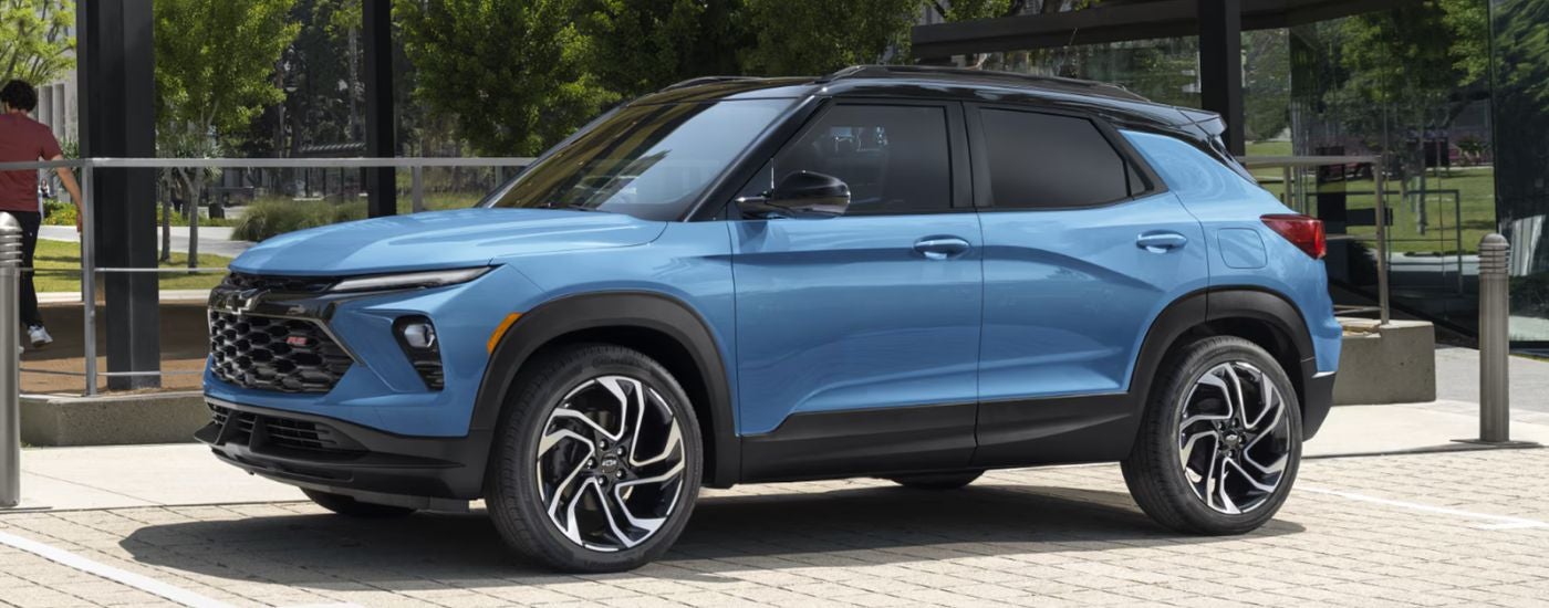 Blue 2026 Chevy Trailblazer RS parked in front of a city glass building.