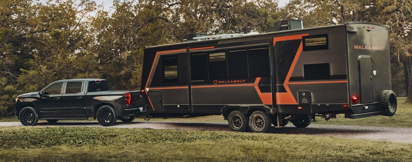 Black 2026 Chevy Silverado 1500 High Country towing a camper