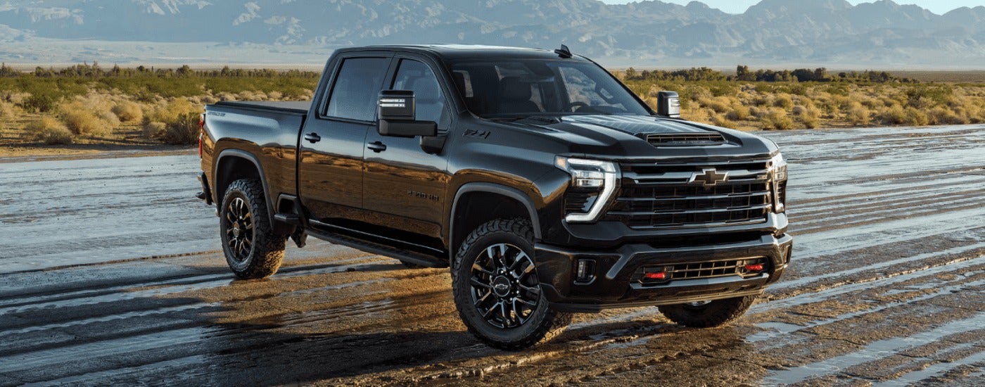 Black 2026 Chevy Silverado 2500 HD parked off-road on an angle
