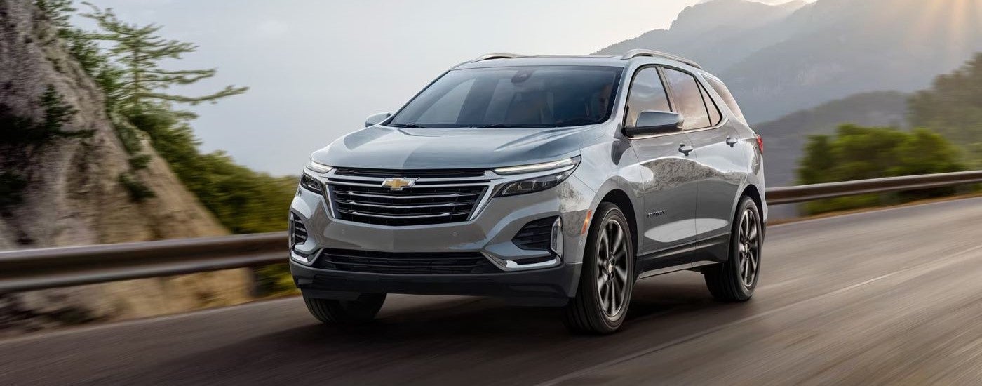 A silver 2024 Chevy Equinox is shown driving on a highway to visit a Chevy dealer near Ripley.
