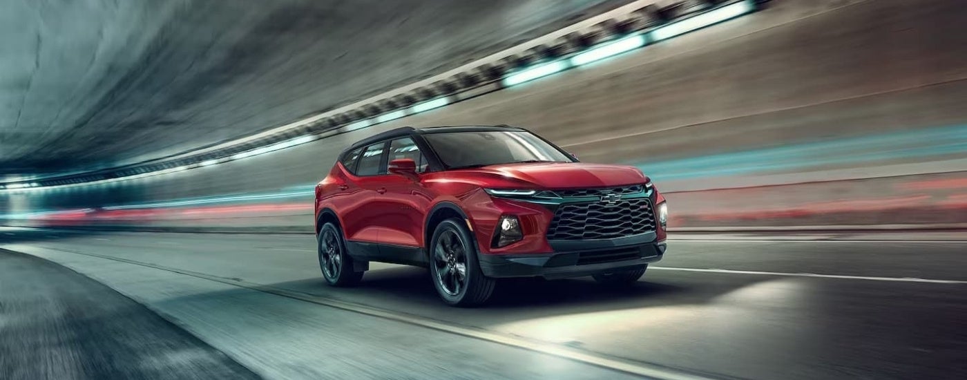 A red 2021 Chevy Blazer driving in a tunnel after visiting Chevy dealers in MS.