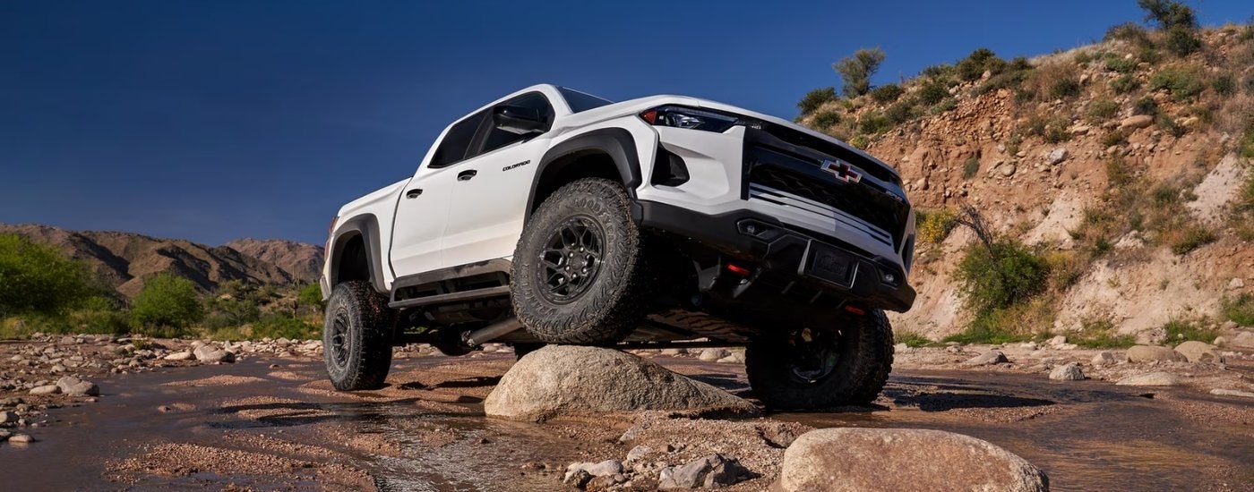 A white 2024 Chevy Colorado ZR2 is shown off-road.