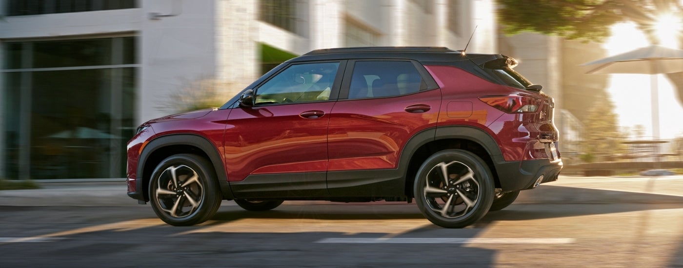 A red 2021 Chevy Trailblazer is shown from the side driving through a city.