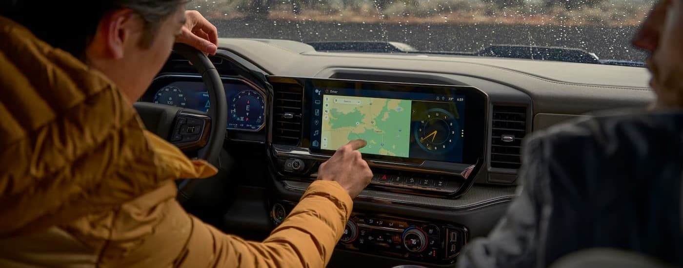 A person using the infotainment screen in a 2027 Chevy Silverado 1500.