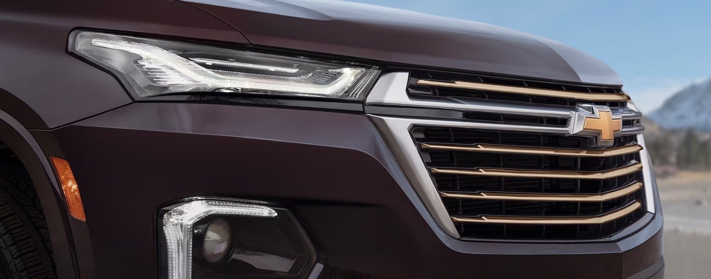 A close up shows the grille and passenger side headlight on a purple 2022 Chevy Traverse.