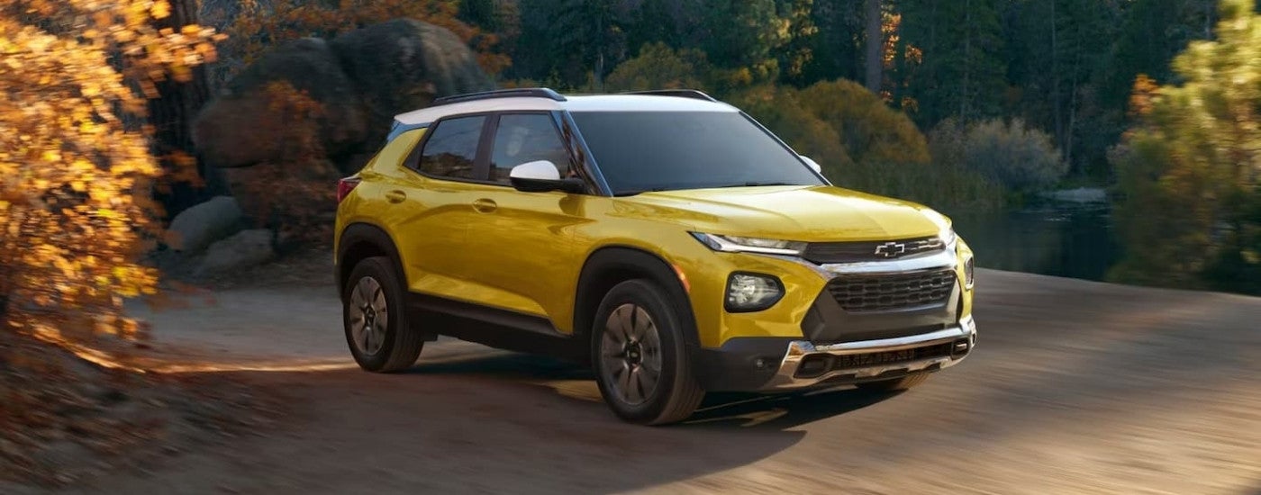 A yellow 2023 Chevy Trailblazer ACTIV is shown driving to a Mississippi used car lot.