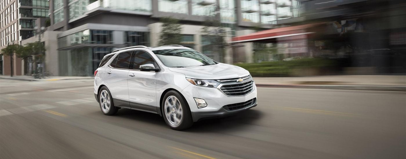 A white 2018 Chevy Equinox is shown from the front at an angle.