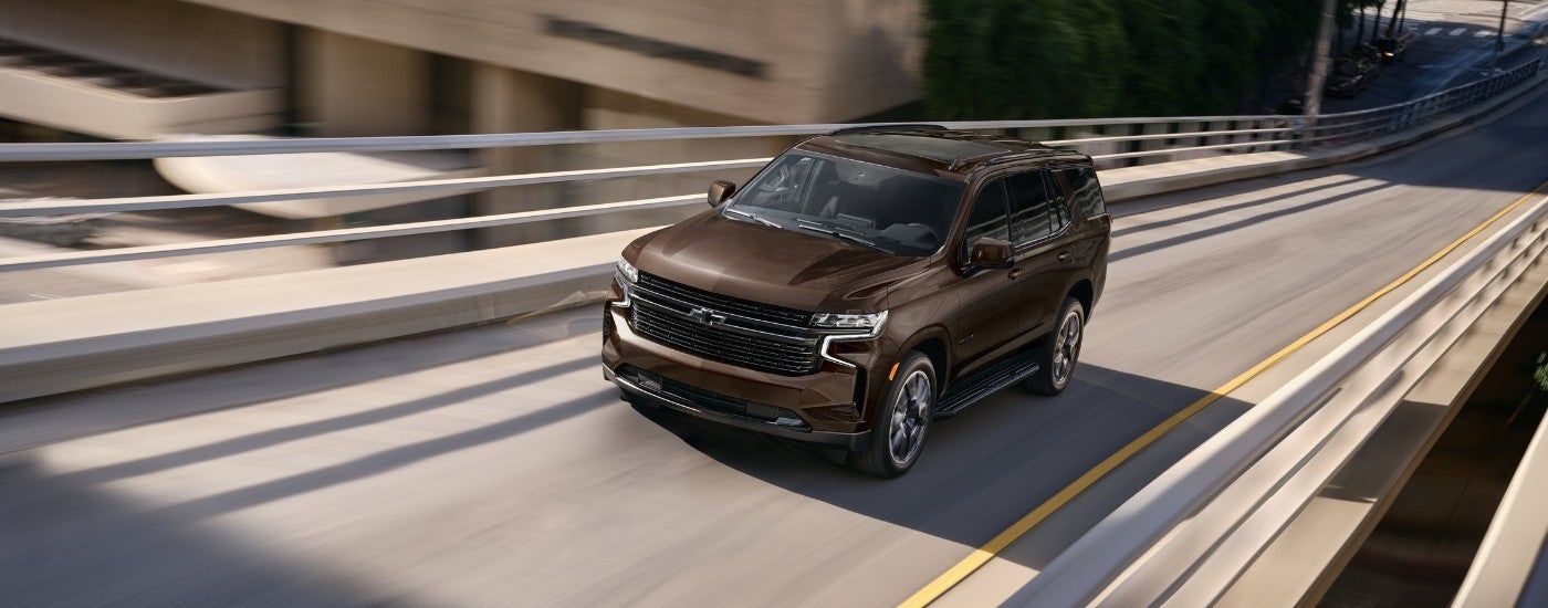 A bronze 2022 Chevy Tahoe driving on the highway near a Selmer Chevrolet dealer.