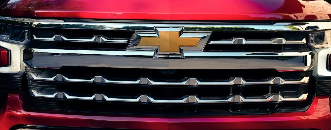  A close up of the grille on a red 2023 Chevy Silverado 1500 LTZ is shown.