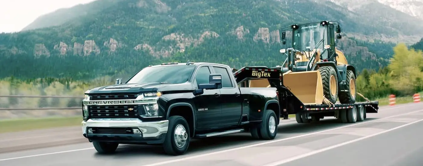 A black 2020 Chevy Silverado 3500 HD is shown towing a trailer.